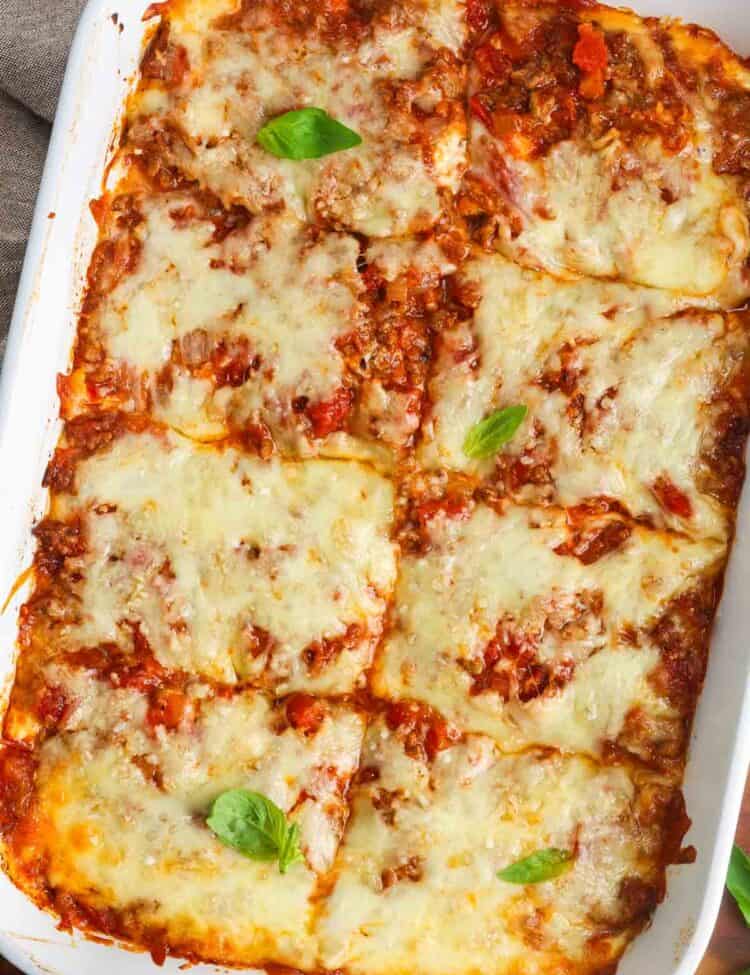 baked zucchini lasagna, cut into 8 squares and garnished with basil leaves.
