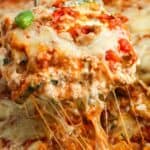 a slice of zucchini lasagna lifted up, showing melty cheese and a creamy texture.