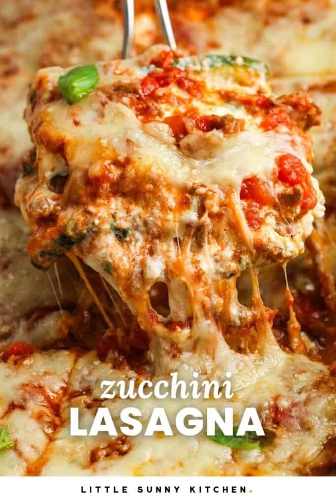 A slice of baked zucchini lasagna with melty cheese, lifted out of the pan. Text overlay on image says "zucchini lasagna"