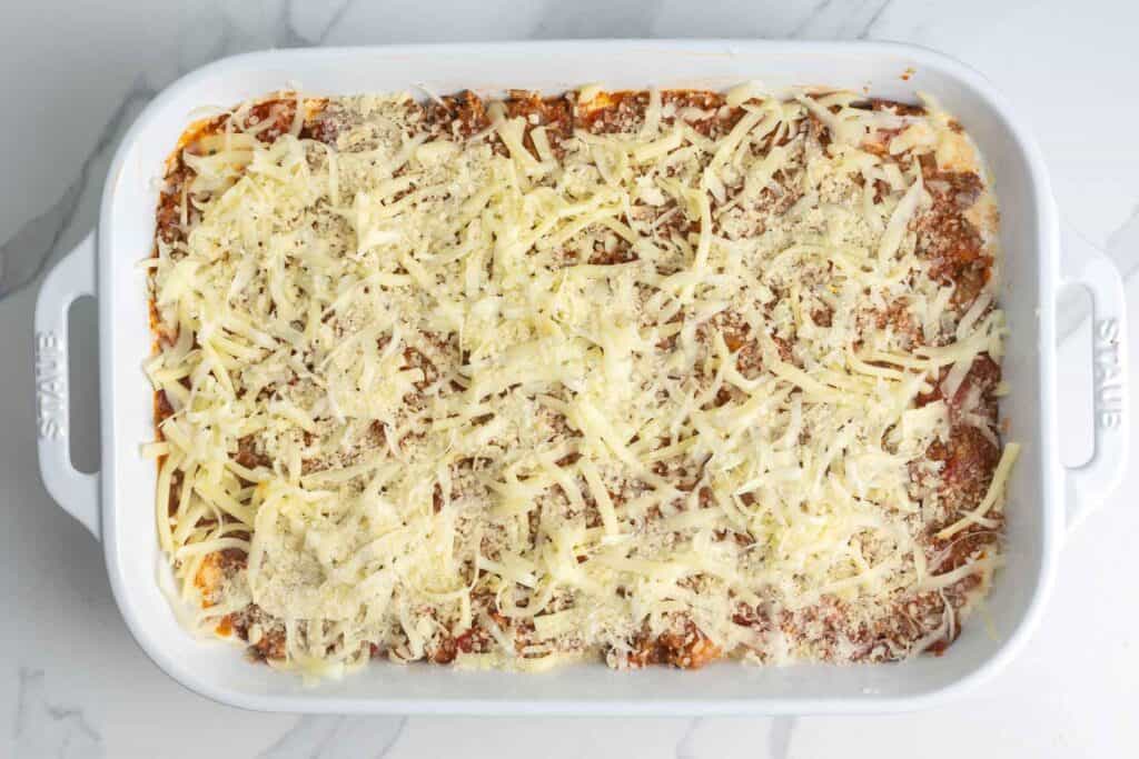 The top layer of zucchini lasagna with ground beef tomato sauce and shredded cheese.