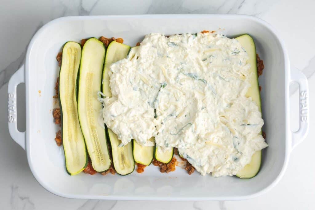 meatsauce, zucchini, and ricotta, layered to create lasagna in a 9x13 inch pan.