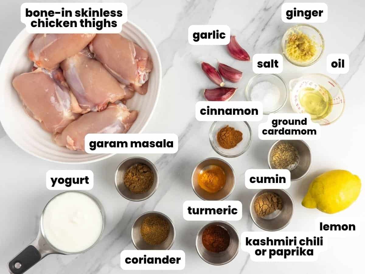 Raw bone-in chicken thighs with spices to make chicken biryani.