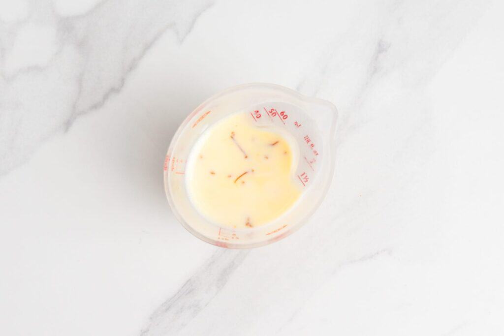 saffron threads steeping in warm milk.