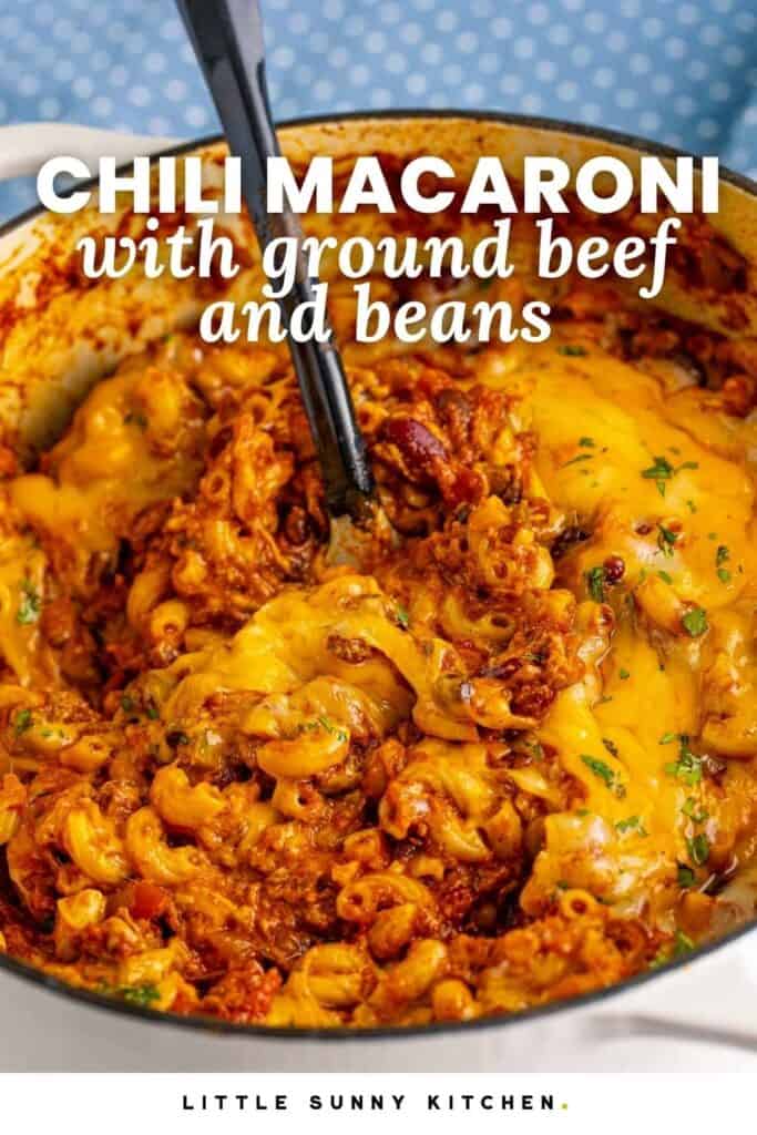 Chili macaroni with ground beef, beans, elbow pasta, and melted cheese in a Dutch oven with text overlay.