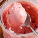 Scoop of homemade strawberry ice cream inside a Ninja Creami pint