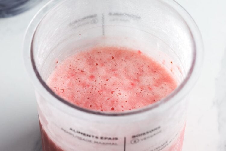 Frozen strawberry ice cream base in a Ninja Creami pint