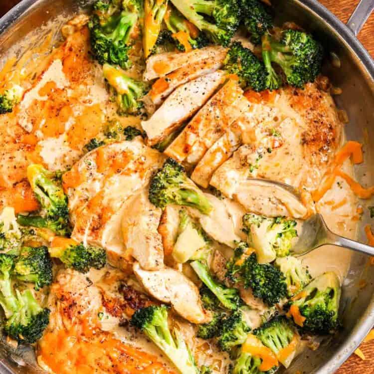 Creamy broccoli cheddar chicken in a skillet. next to the skillet are bowls of pasta.
