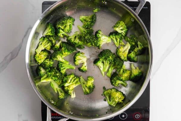 broccoli florets, sauteed in a skillet.