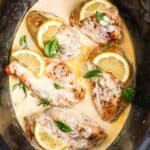 slow cooker lemon chicken in a creamy sauce, garnished with fresh basil.