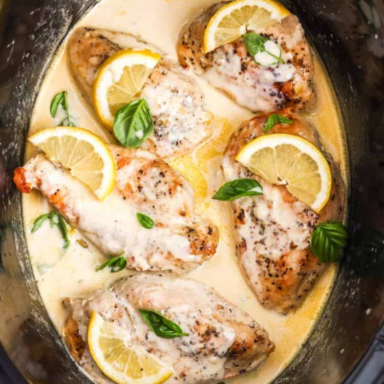 slow cooker lemon chicken in a creamy sauce, garnished with fresh basil.