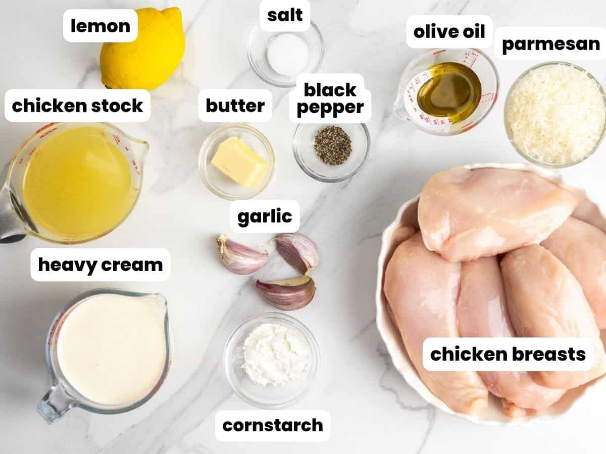 raw chicken breasts with the ingredients for slow cooker lemon chicken.