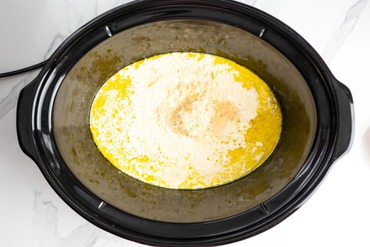 cream and parmesan added to a crockpot to make a sauce.