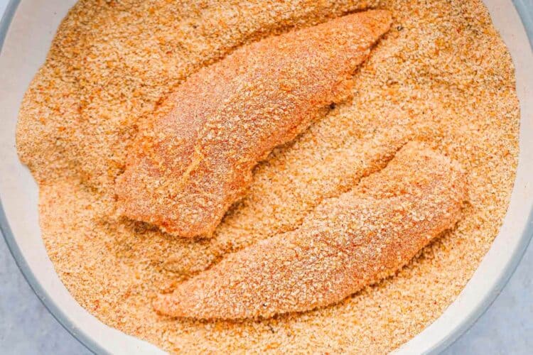 Chicken tenders coated in seasoned breadcrumbs before air frying.