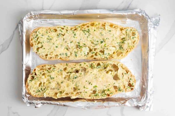 Garlic butter spread over ciabatta halves before baking.