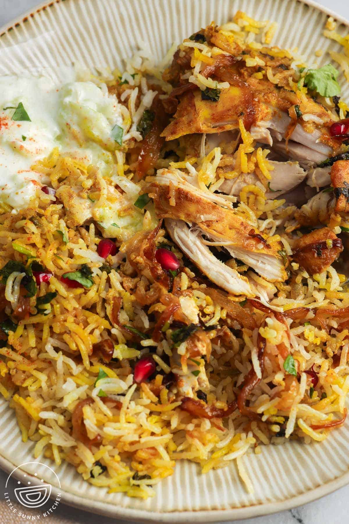 tender chicken biryani with rice on a plate.
