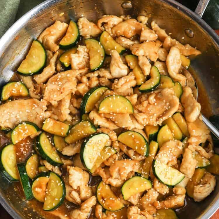 chicken zucchini stir fry in a light ginger sauce, in a skillet.