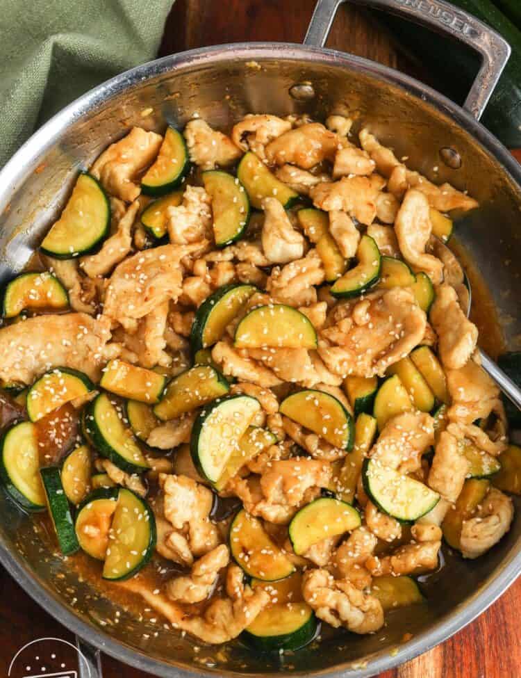 chicken zucchini stir fry in a light ginger sauce, in a skillet.