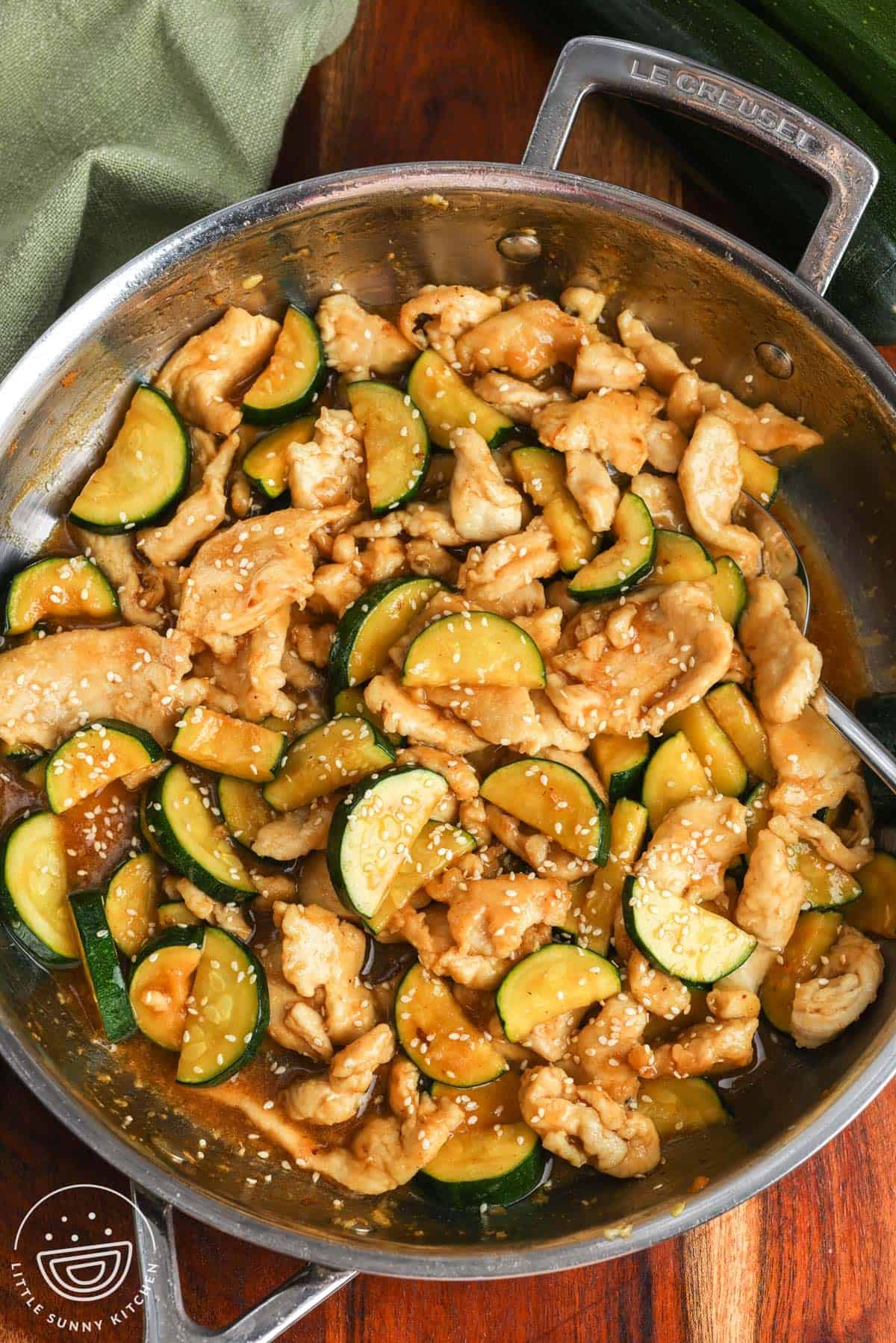 chicken zucchini stir fry in a light ginger sauce, in a skillet.