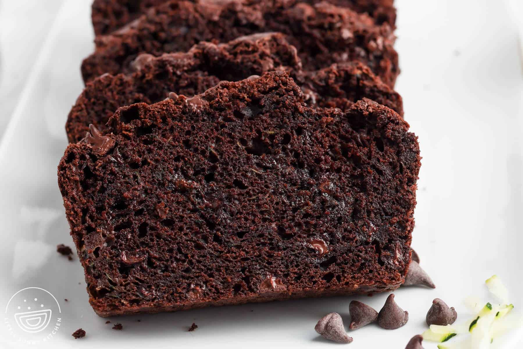 closeup of a slice of double chocolate zucchini bread that shows a dark color and melty chocolate chips.