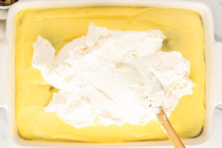 Spreading whipped cream over the chilled vanilla pudding layer
