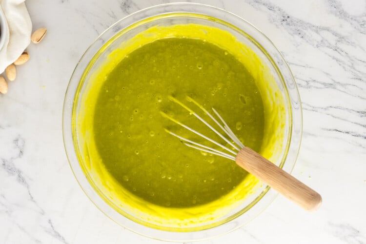 Smooth green pistachio cake batter mixed in a glass bowl
