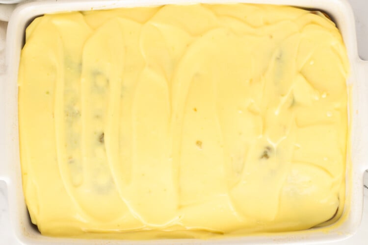 Smooth vanilla pudding layer covering the pistachio poke cake