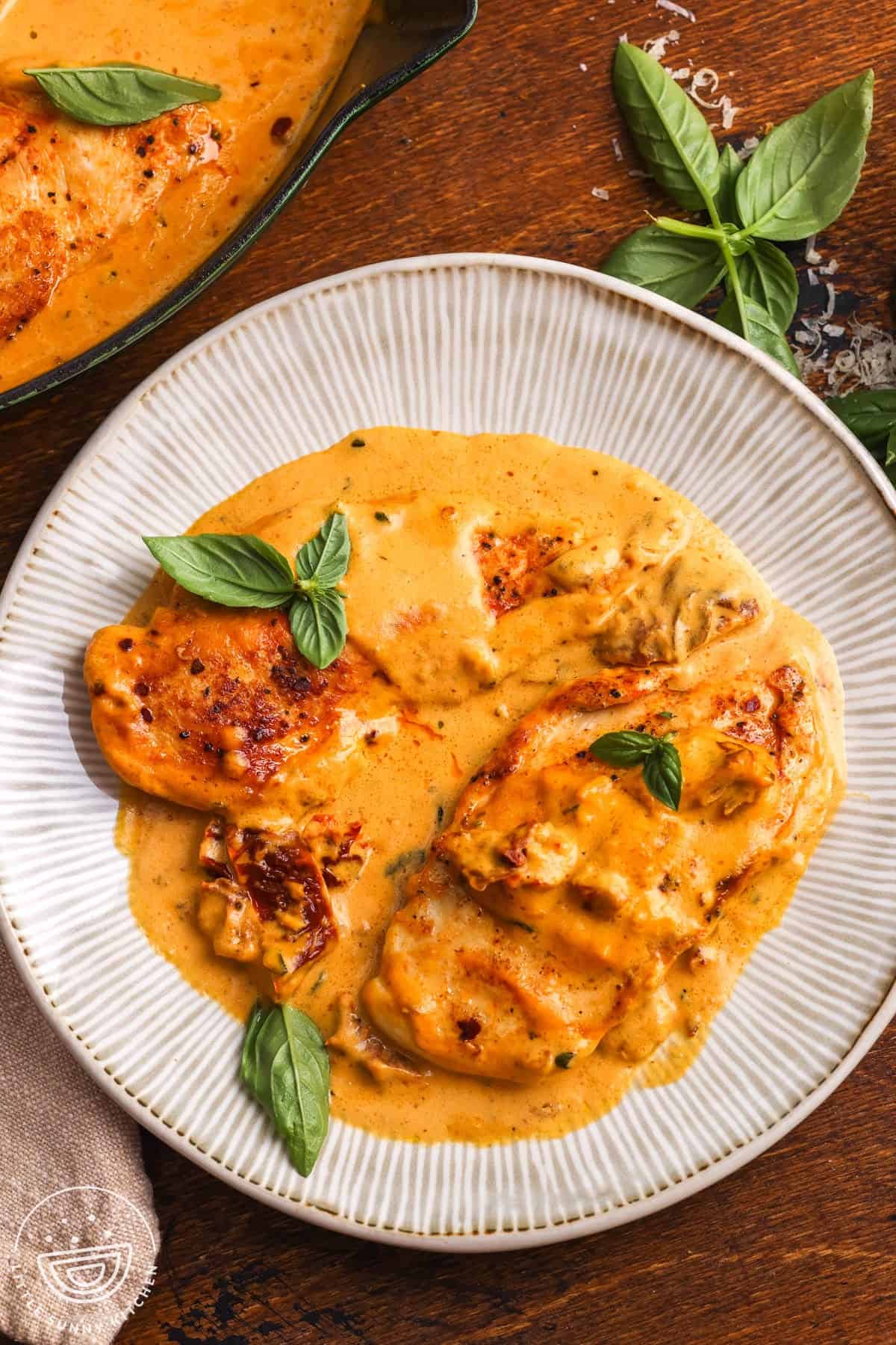 Pumpkin Marry Me Chicken with golden chicken cutlets, creamy pumpkin sauce, sun-dried tomatoes, and fresh basil.