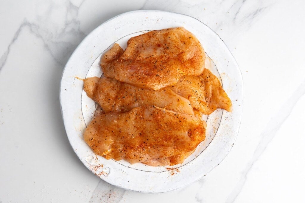 Thin chicken breast cutlets seasoned with salt, black pepper, and smoked paprika.