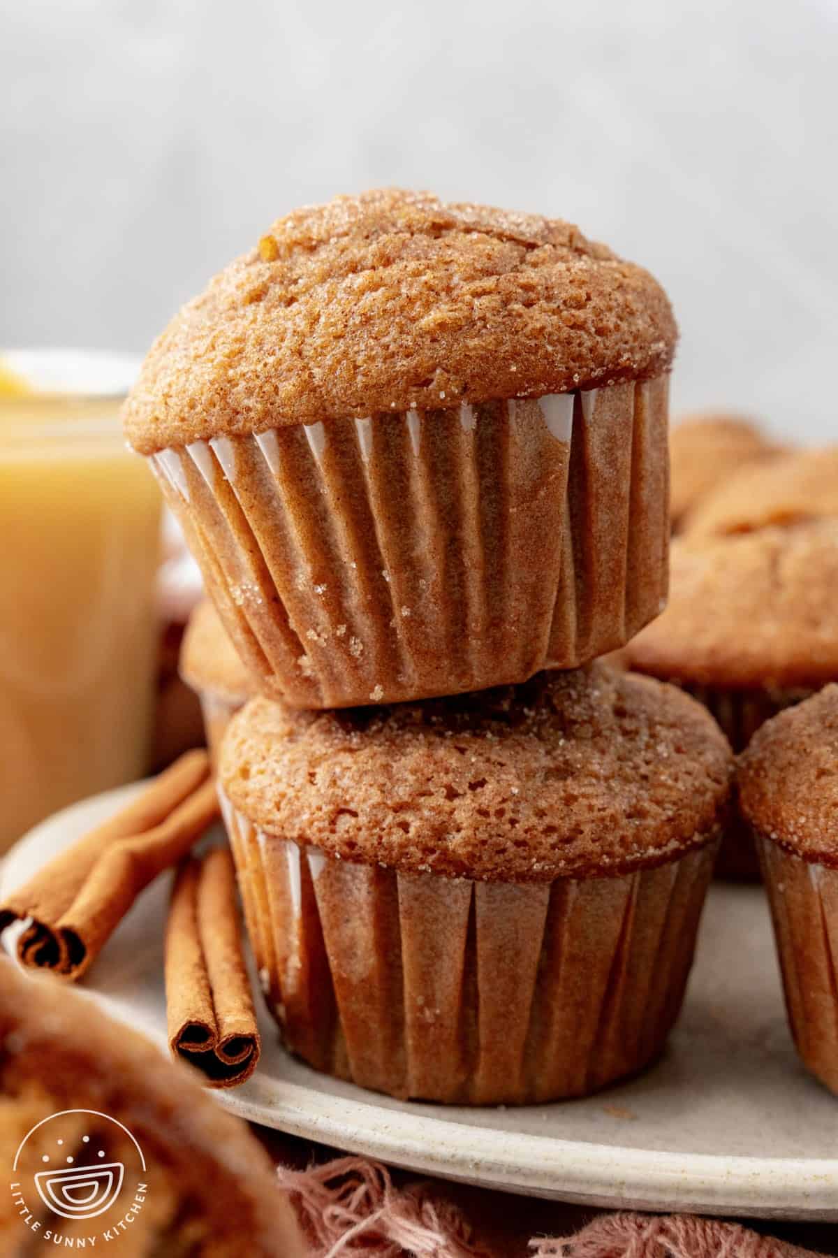 two apple cinnamon muffins on a plate.