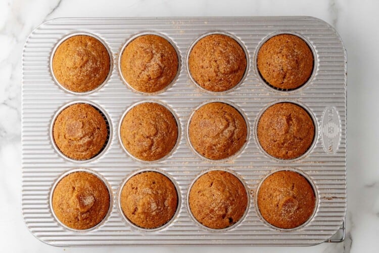 baked applesauce muffins in a muffin tin.