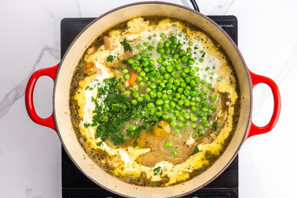 peas, cream, and fresh herbs added to chicken stew recipe at the end of cooking.