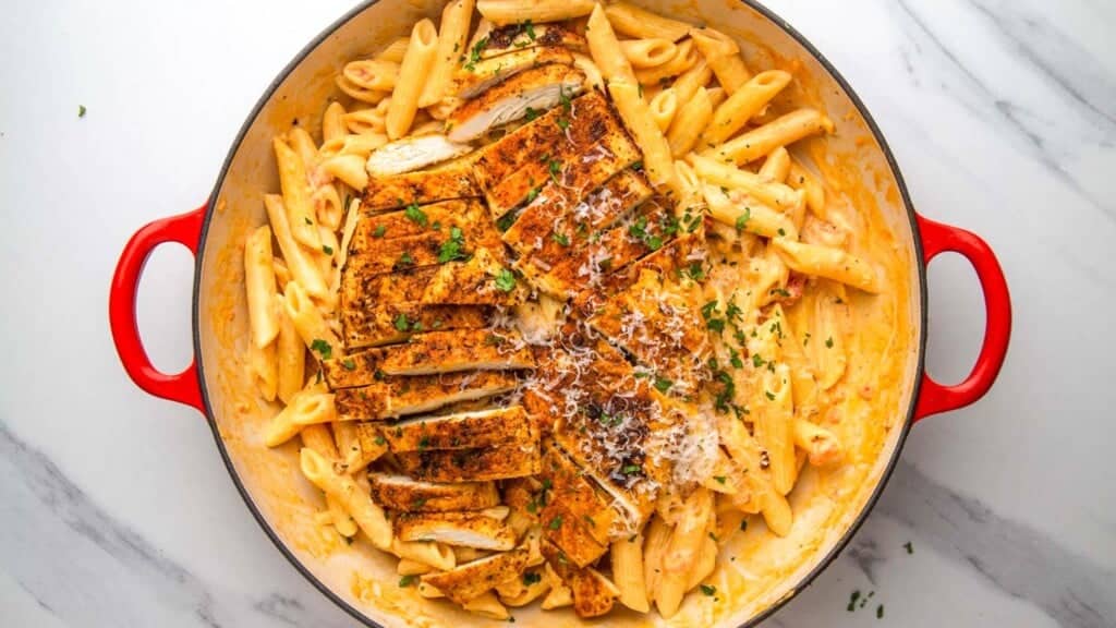 creamy cajun pasta topped with sliced seared chicken breast.