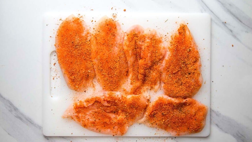 six chicken cutlets, coated with cajun seasoning.