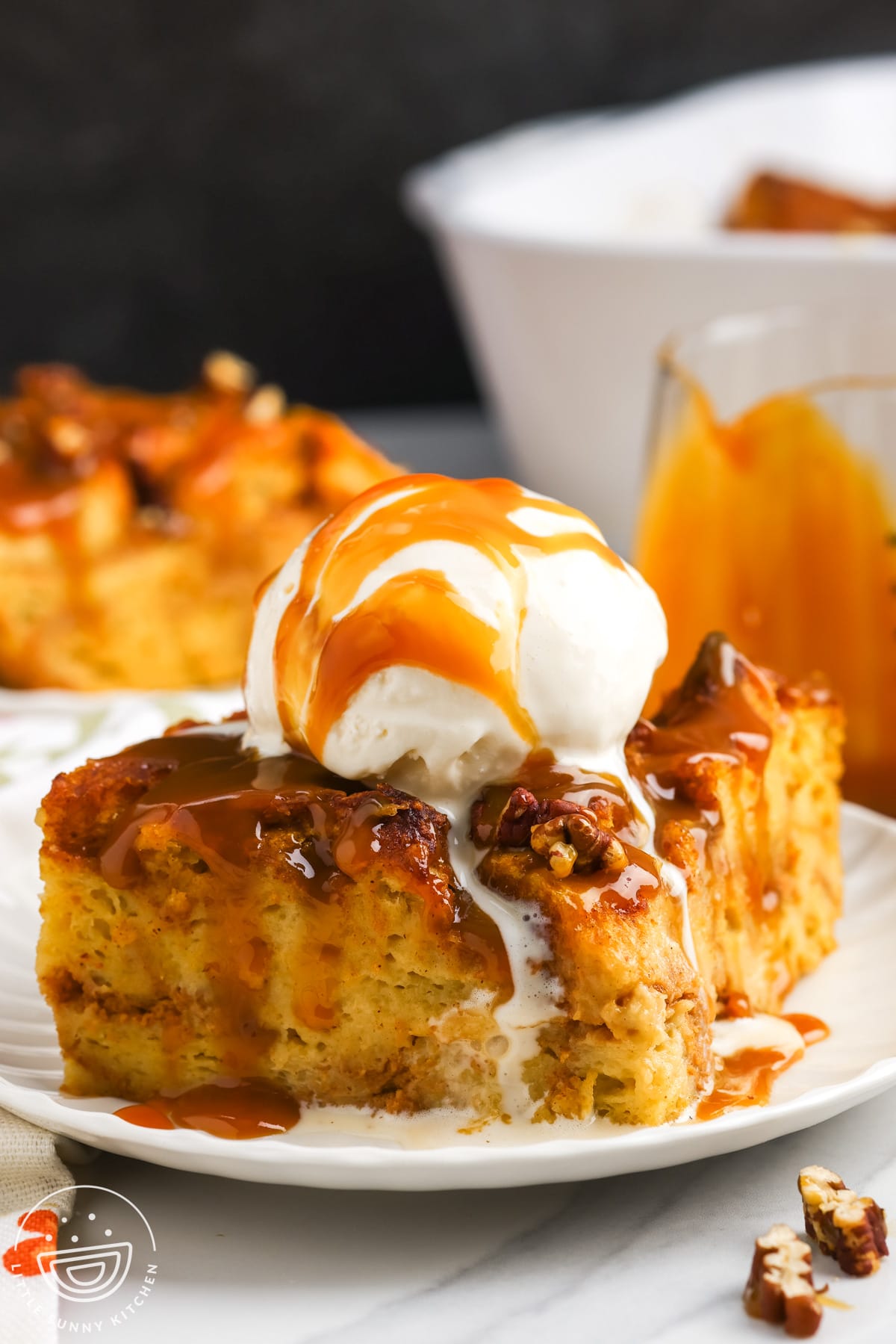 a slice of bread pudding made with pumpkin, topped with caramel and ice cream.