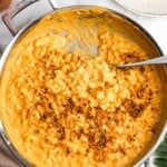 pumpkin macaroni and cheese topped with herbed breadcrumbs, on a counter.