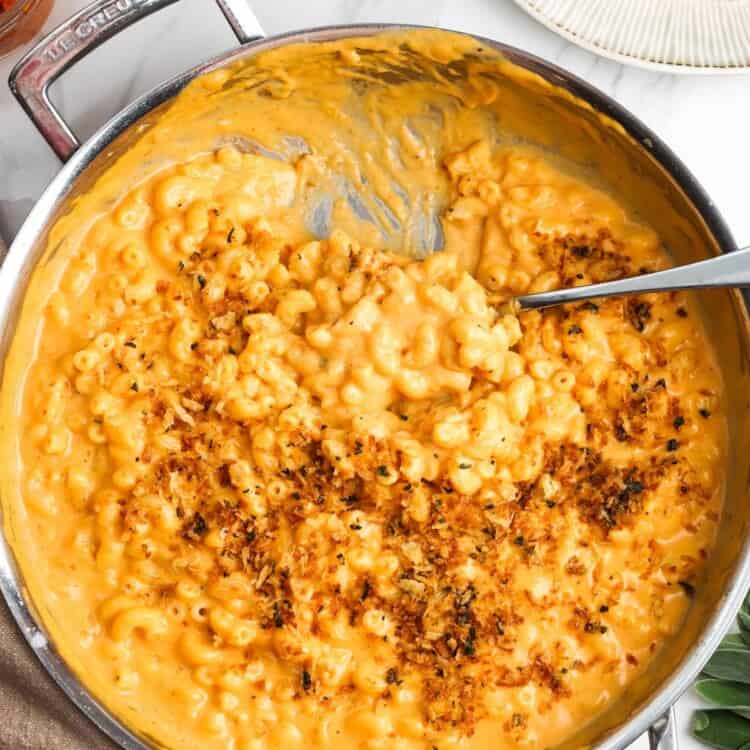 pumpkin macaroni and cheese topped with herbed breadcrumbs, on a counter.