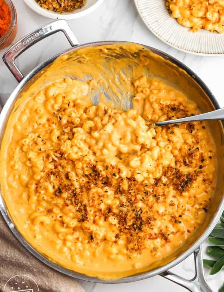 pumpkin macaroni and cheese topped with herbed breadcrumbs, on a counter.