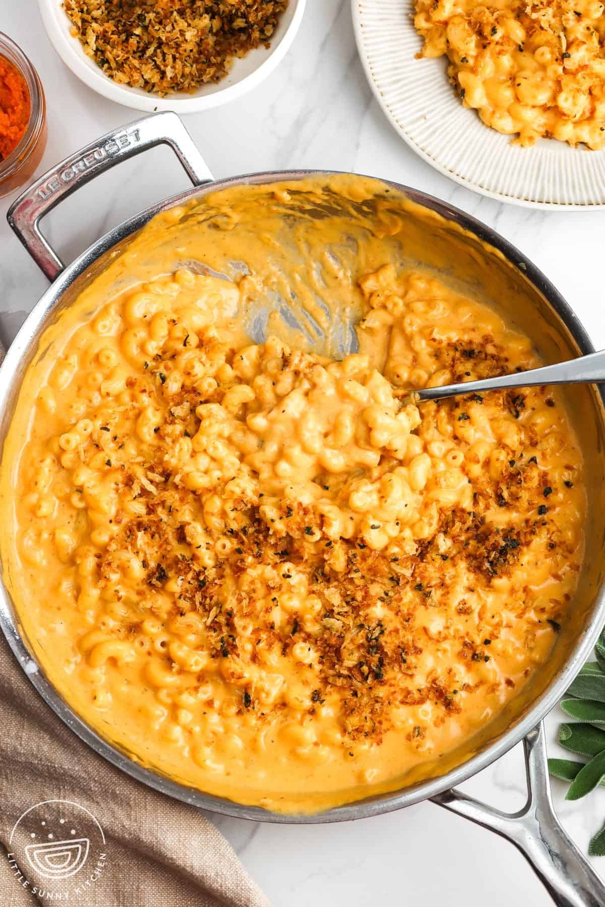 pumpkin macaroni and cheese topped with herbed breadcrumbs, on a counter.