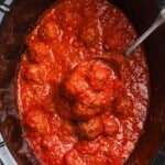 cooked meatballs in sauce in a crock pot, viewed from overhead.