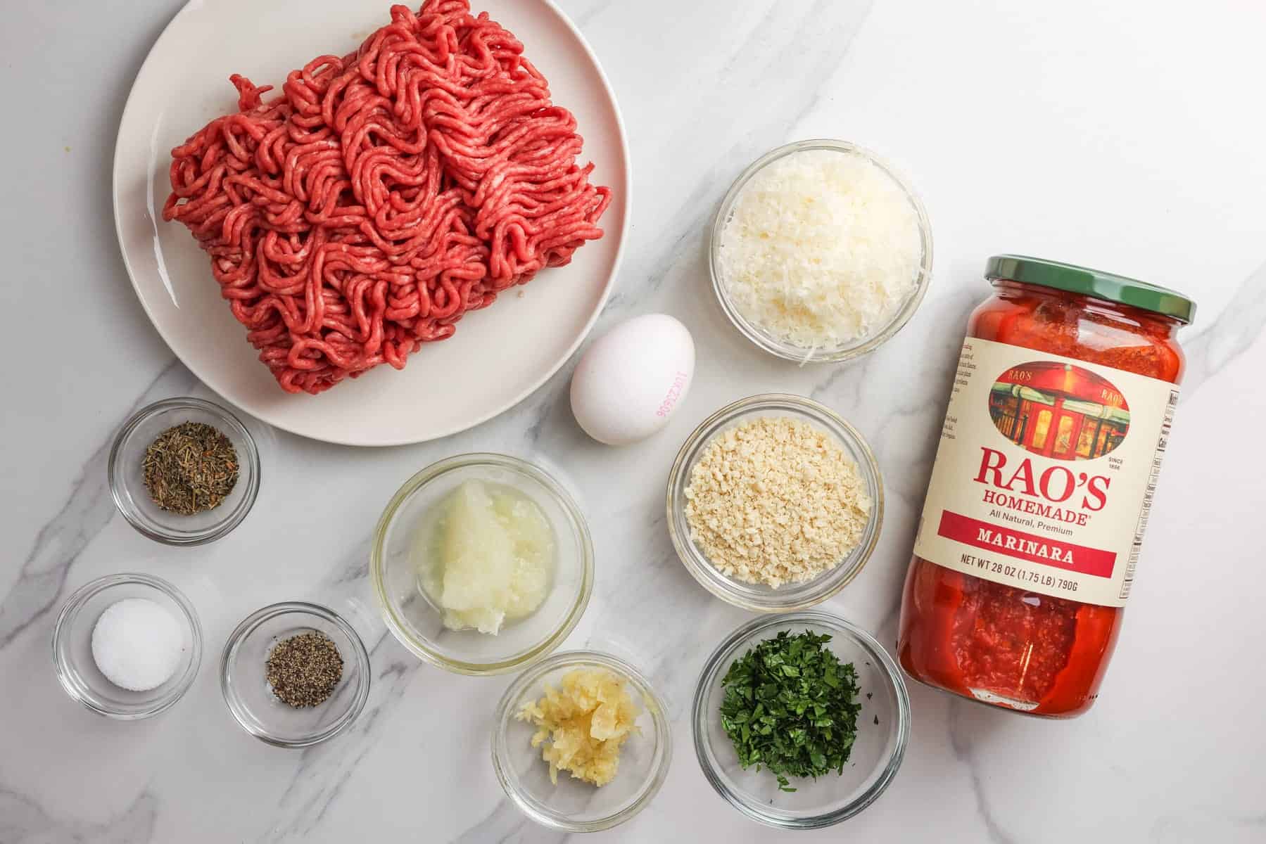 A plate of ground beef next to the ingredients for slow cooker meatballs with tomato sauce.