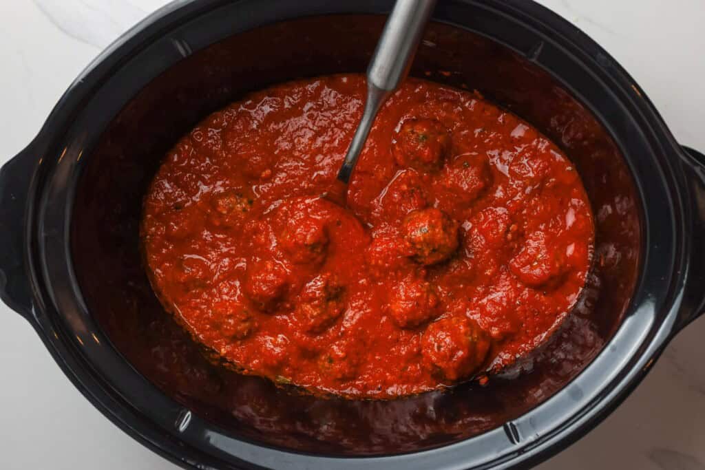 cooked meatballs with marinara sauce in a slow cooker.
