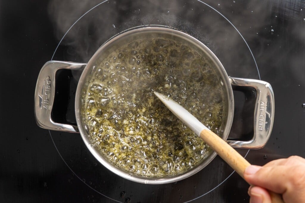 Garlic and dried mint sizzling in butter in a small saucepan.