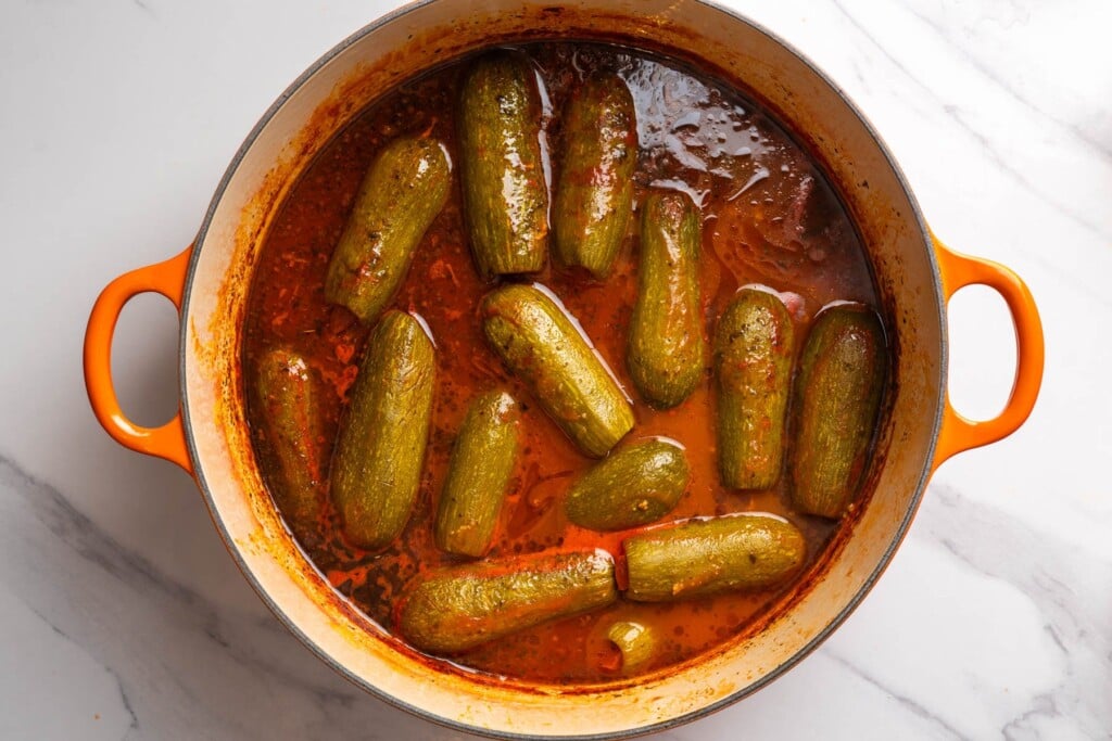 Cooked kousa mahshi in a rich tomato sauce, ready to serve.