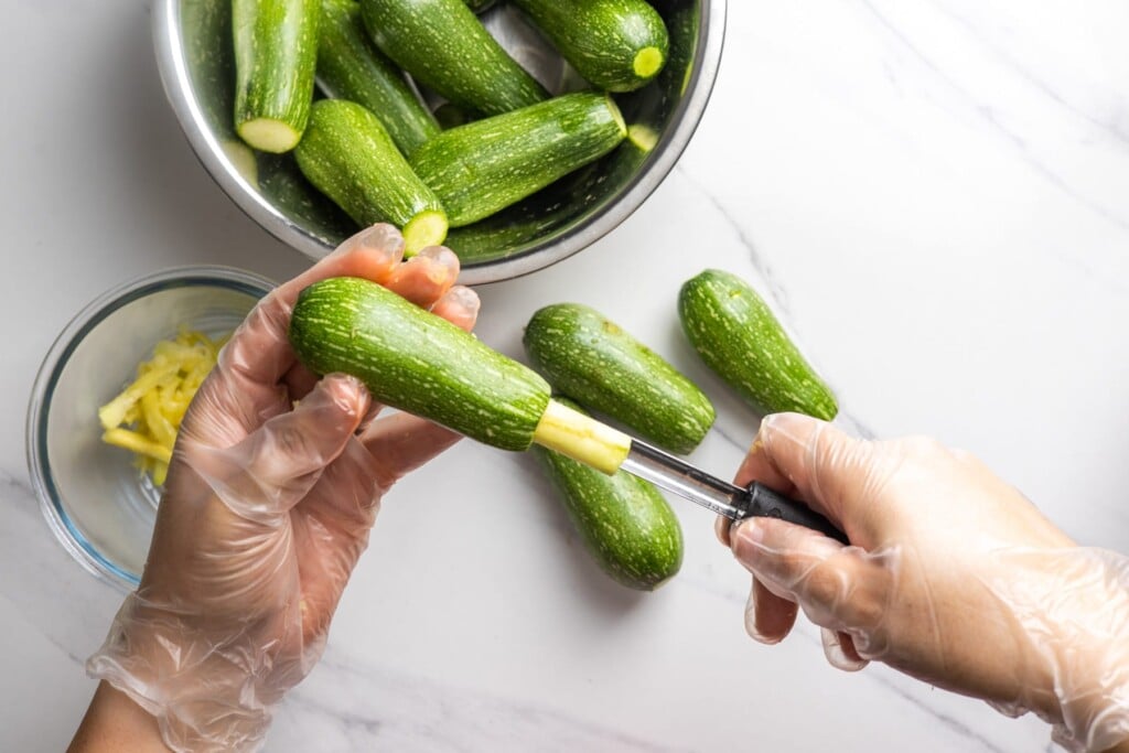 Hollowing out a zucchini with a zucchini corer.