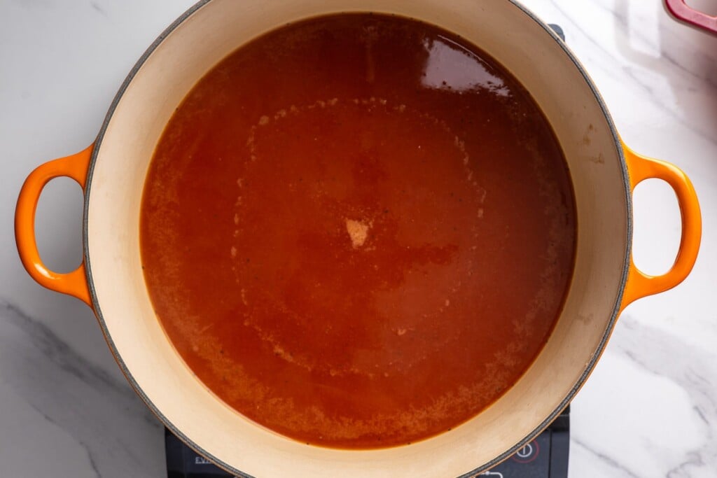 Tomato cooking liquid in a large Dutch oven.