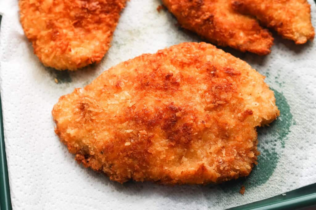 crispy fried panko breaded chicken cutlets resting on a paper towel