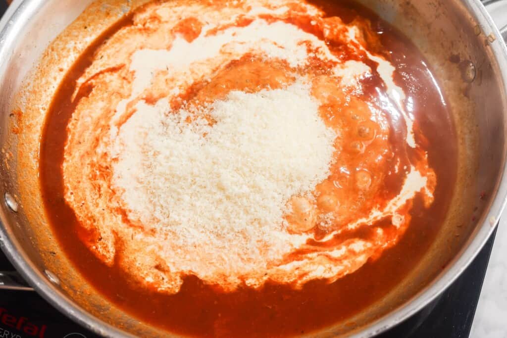adding cream and Parmesan to a red cajun sauce over low heat.