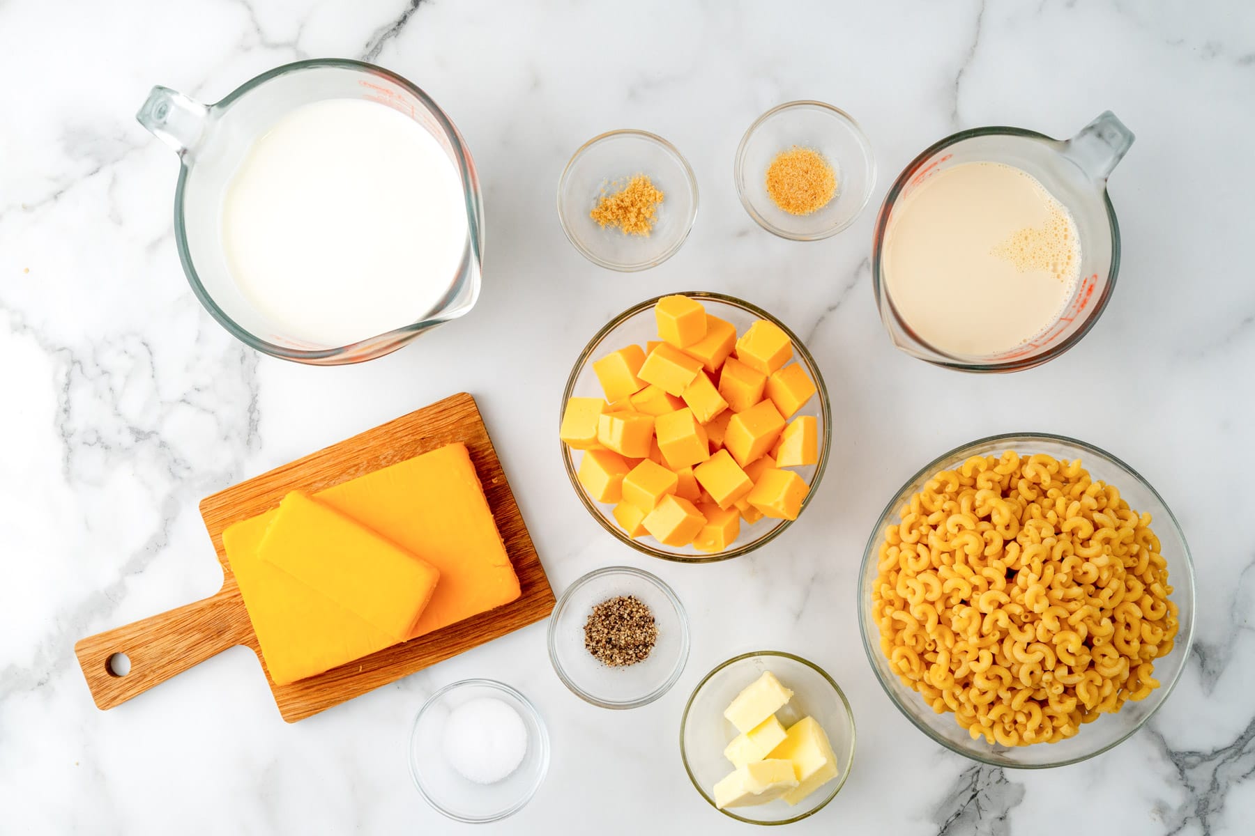 Ingredients for crockpot mac and cheese, including elbow noodles, velveeta, and cheddar.