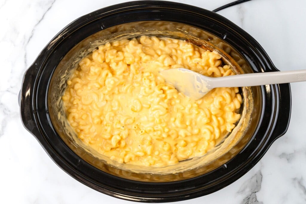 creamy macaroni and cheese sauce in a crockpot, after cooking and stirring.