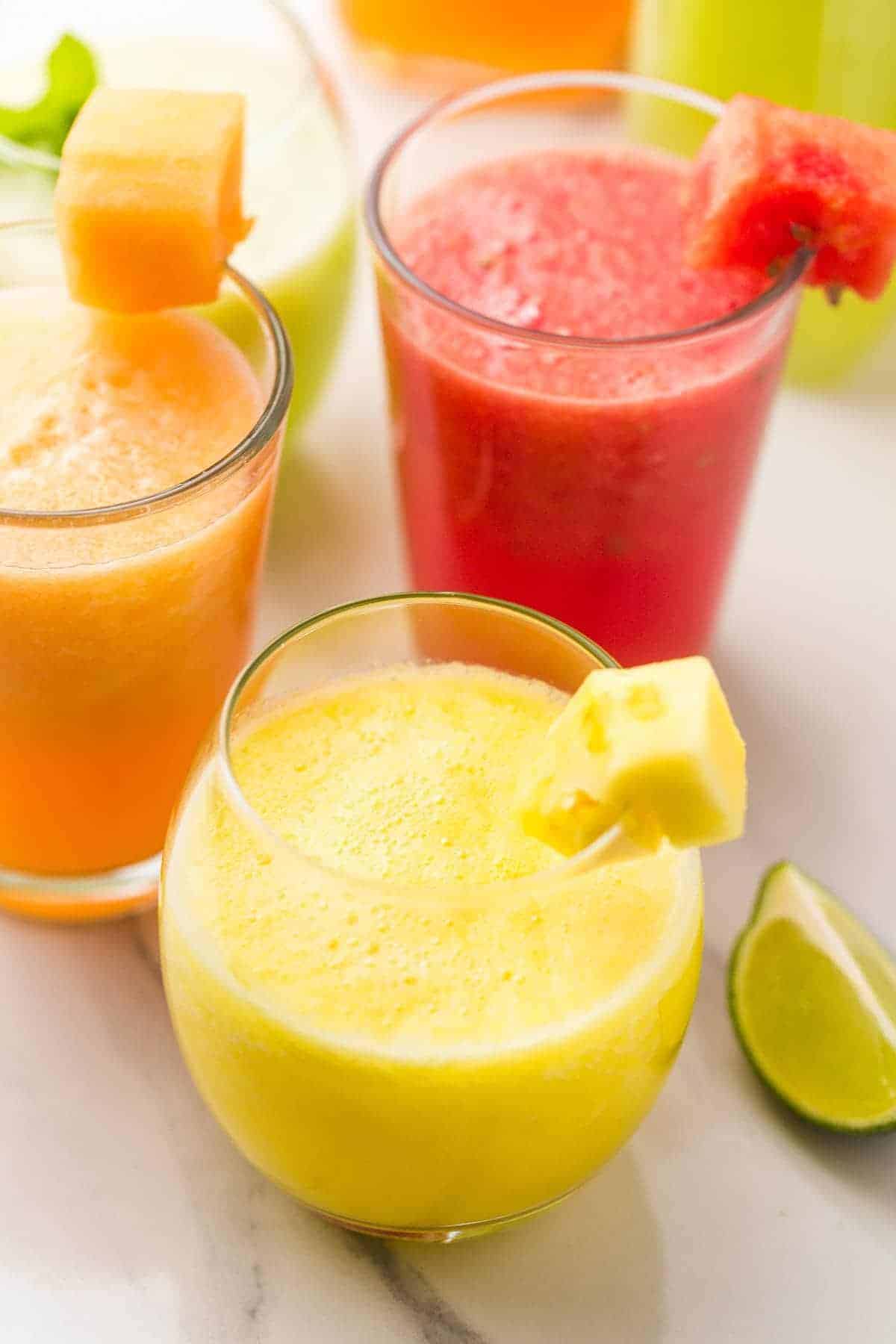 Un vaso de Agua fresca de piña sobre un fondo de más bebidas